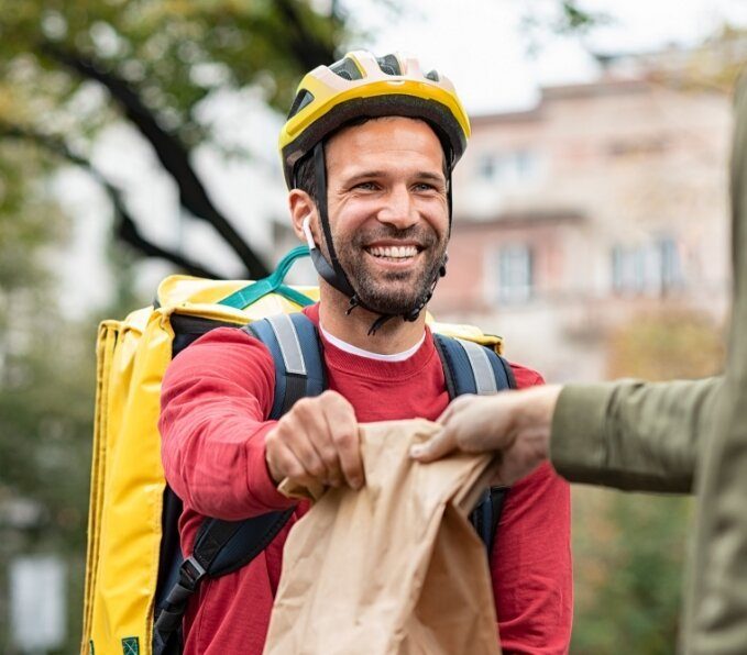 delivery-man-giving-take-away-food-DBXUQTG