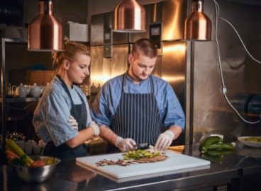 male-chef-with-assistant-standing-in-a-kitchen-pre-PCVW5CR