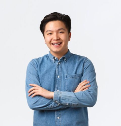 smiling-asian-guy-looking-happy-at-camera-cross-ar-4BKFZNZ