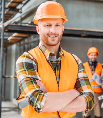 smiling-builder-standing-at-construction-site-with-2021-08-30-19-58-46-utc