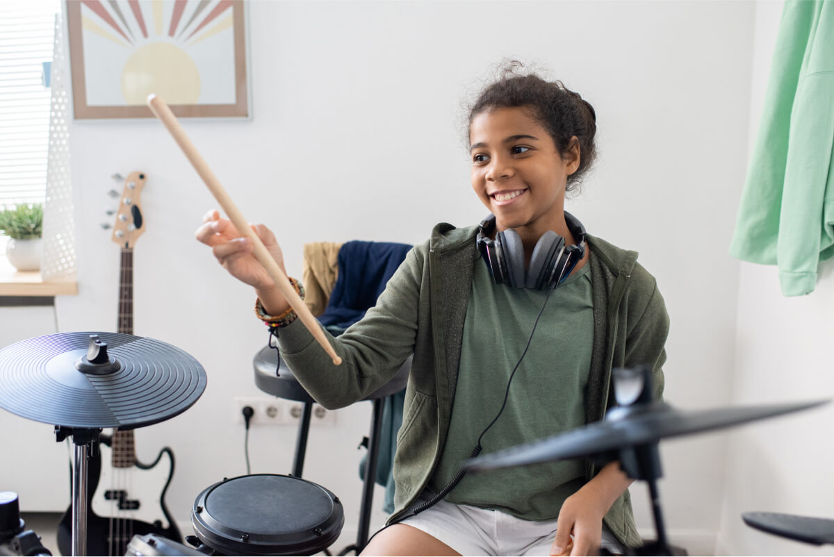happy-cute-schoolgirl-with-drumsticks-hitting-drum-2021-12-16-00-28-52-utc
