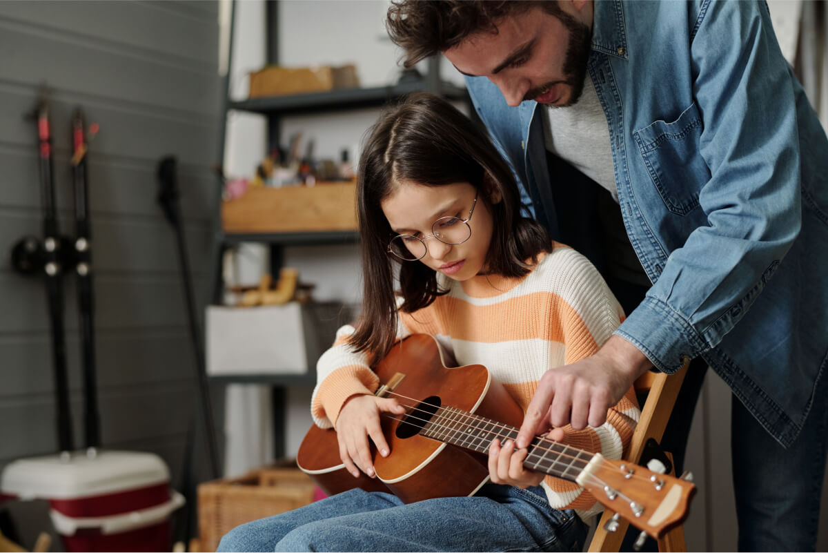 little-girl-in-eyeglasses-learning-to-play-guitar-2022-04-29-00-27-38-utc