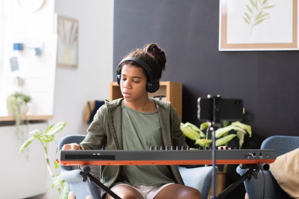 cute-preteen-biracial-schoolgirl-playing-piano-key-2022-01-19-00-15-27-utc