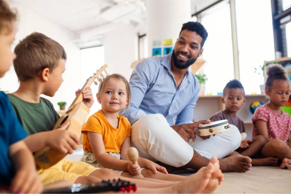 nursery-school-children-with-man-teacher-sitting-o-2022-01-19-00-04-00-utc