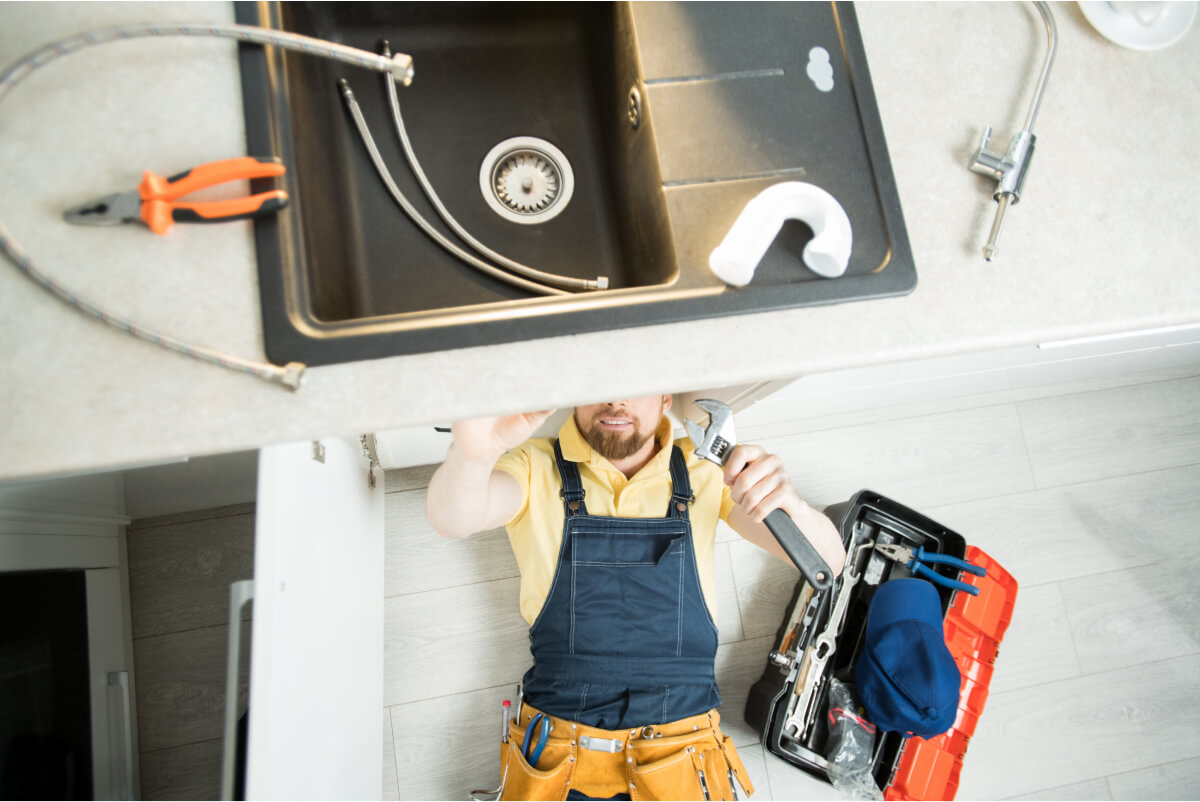 plumber-repairing-pipe-in-kitchen-2021-09-24-03-51-32-utc