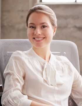 young-white-woman-sitting-at-office-desk-smiling-t-2021-08-26-16-14-58-utc