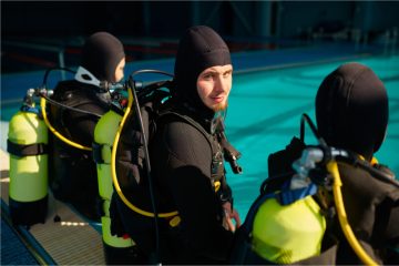 divemaster-and-two-divers-preparing-for-the-dive-2021-09-18-17-33-15-utc